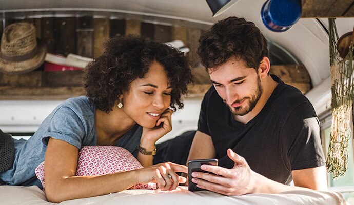 man and woman looking at a mobile phone